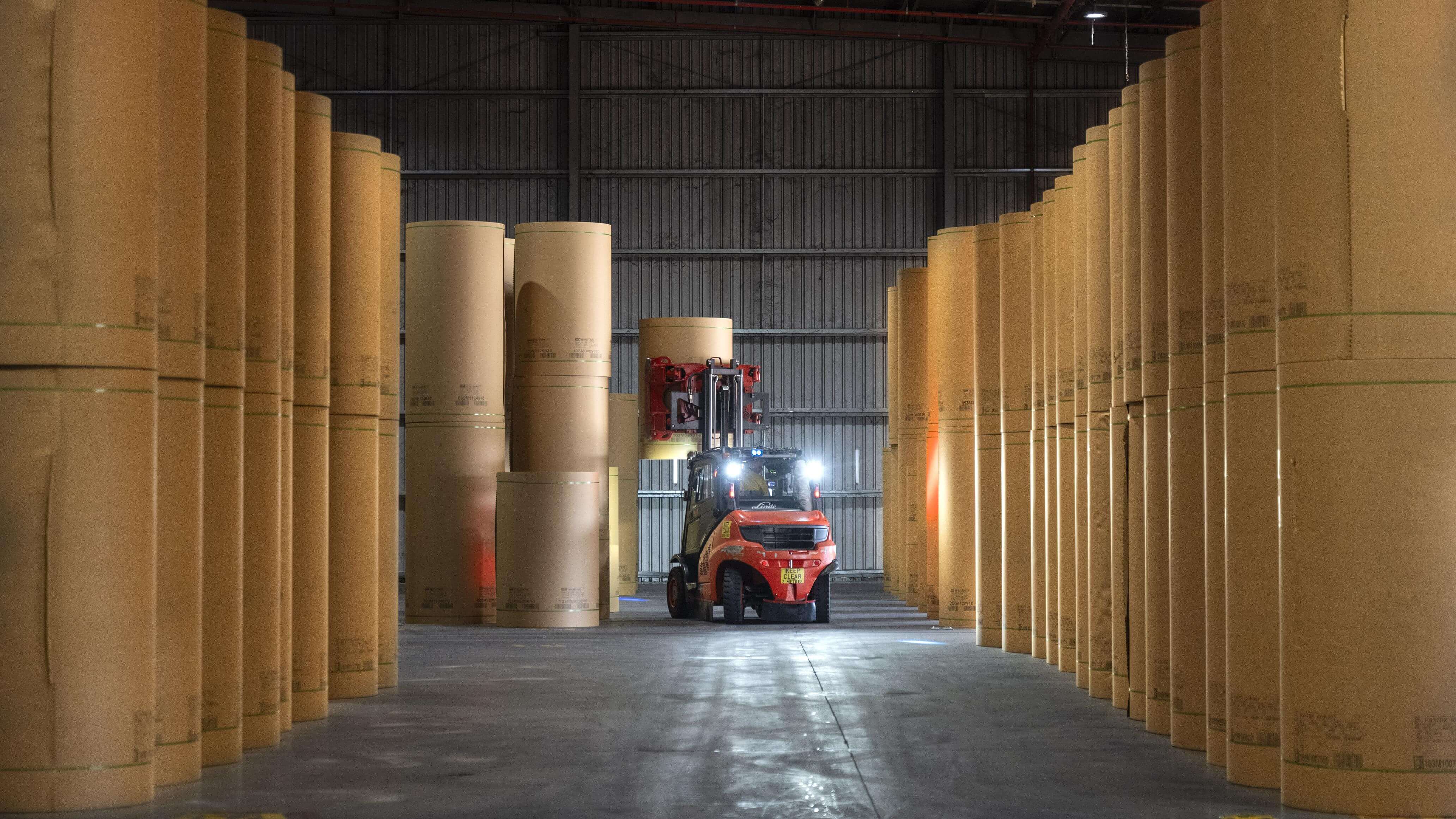 Paper reels warehouse with forklist driver