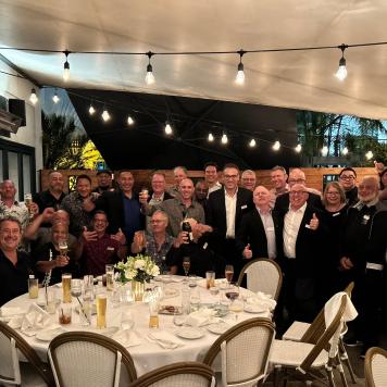 A group of people at a restaurant smile at the camera