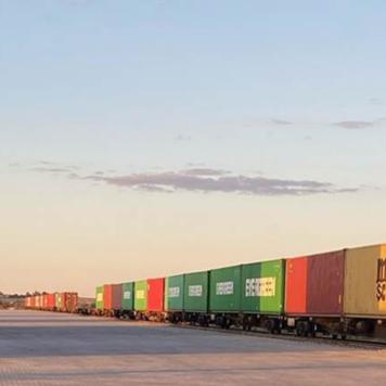 A long train with lots of different coloured containers on it