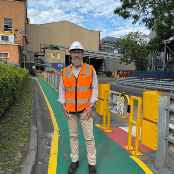 A man standing on a work site in a hi-vis vest